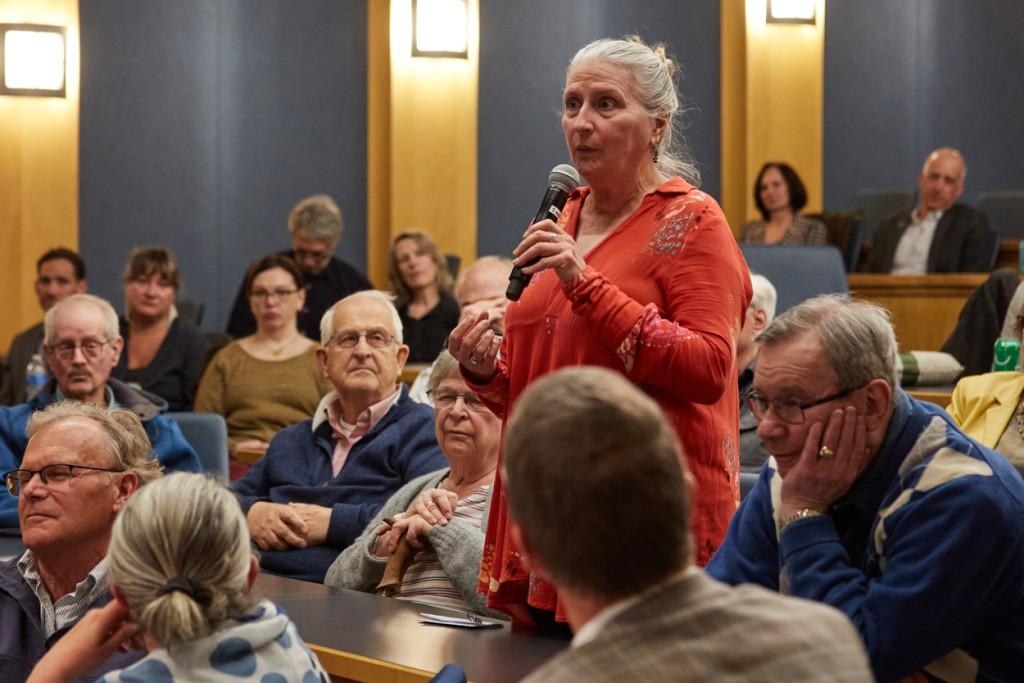 A community member asks a question from the audience of a C G H lecture